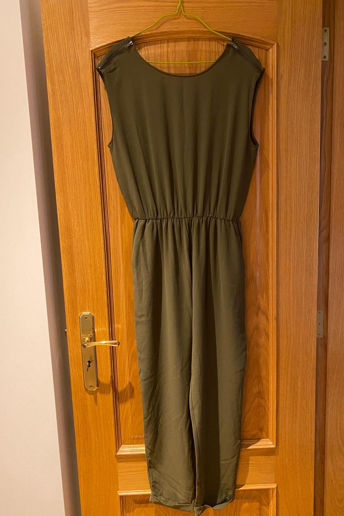 Rear view of an olive green sleeveless jumpsuit with an elasticated waist and ankle-length.