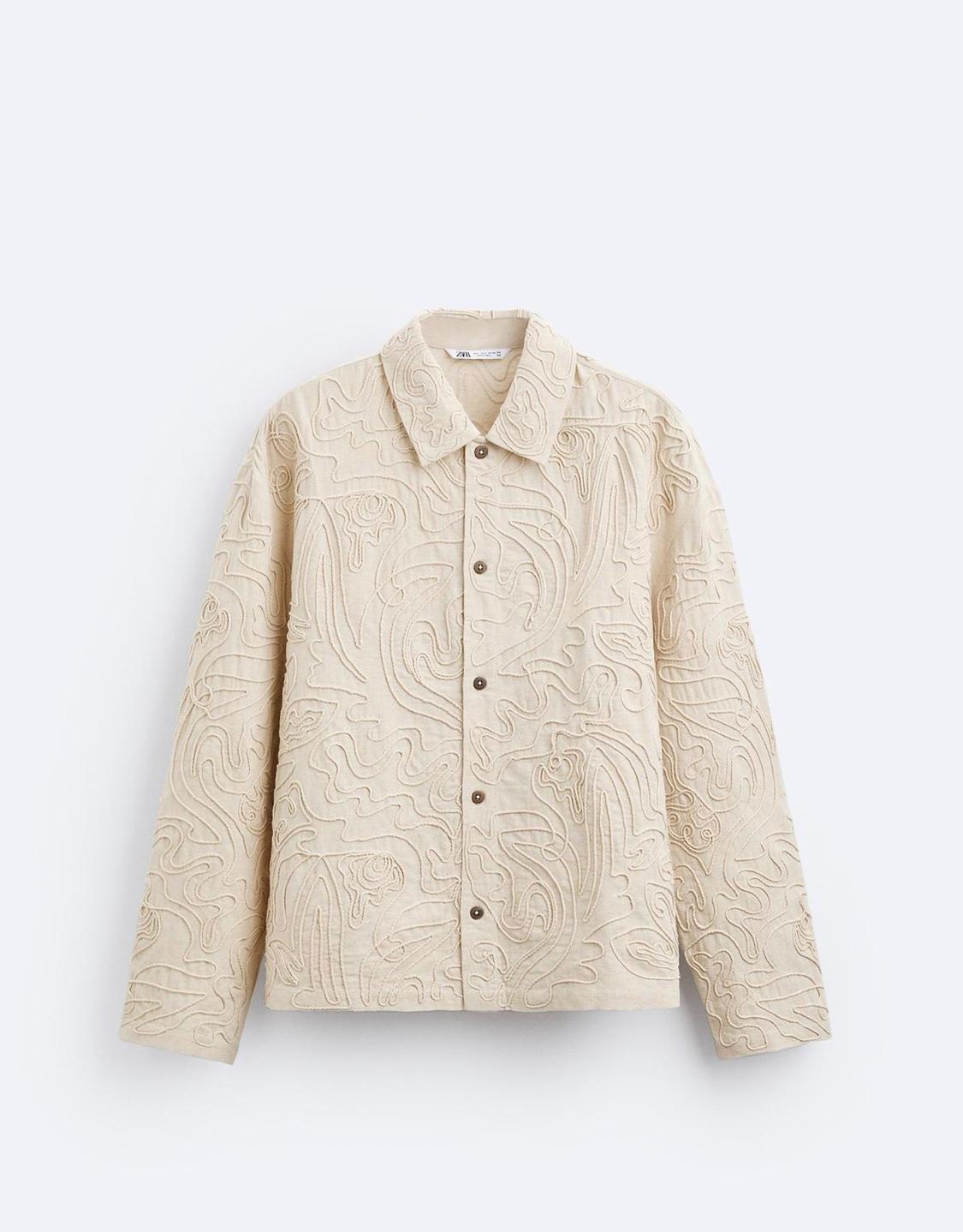 Beige jacket with embossed embroidery design, front buttons and classic collar. White background. Visible label: "Zara Woman".