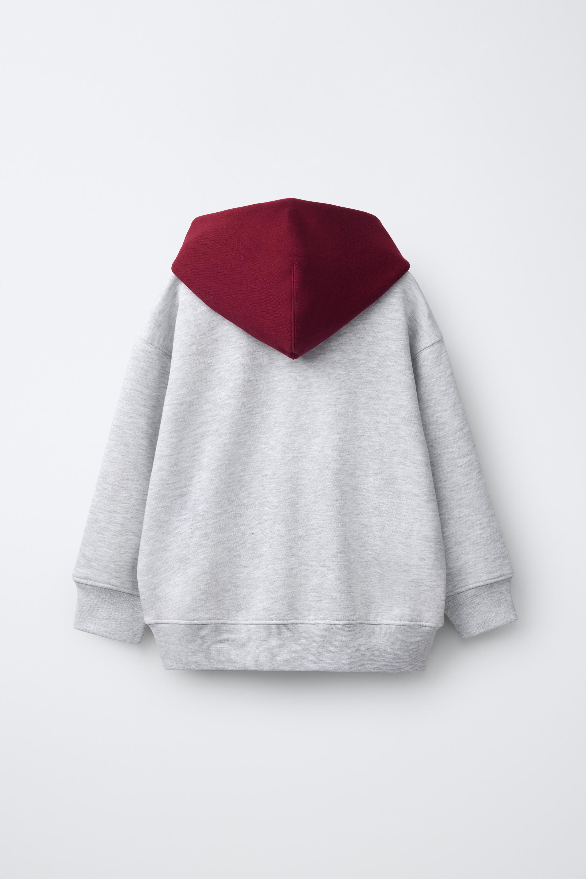 SWEAT À CAPUCHE ET INSCRIPTION