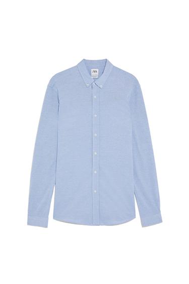 Light blue long-sleeve shirt with front buttons and buttoned collar on a white background. Visible label with the text ZARA.