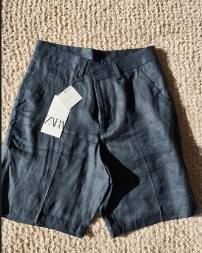 Dark fabric shorts on a beige rug, with a white label that says "ZVR".