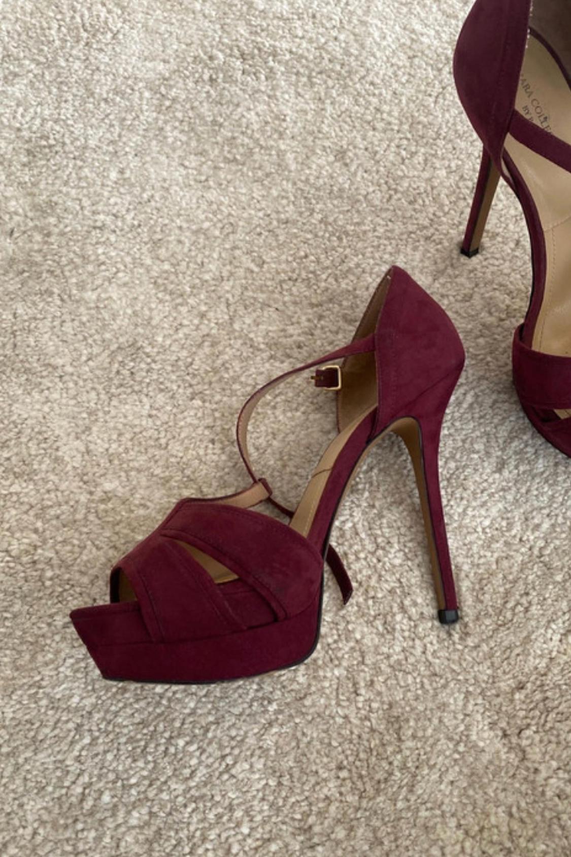 Close-up of burgundy sandals with a high heel and platform.