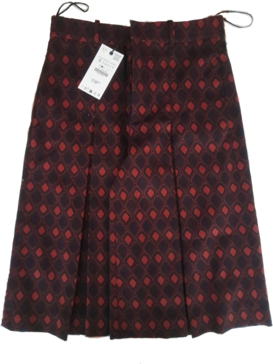 Skirt with a geometric print in red and black tones, visible label with size details and barcode.