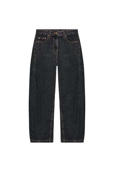 Front view of black wide-leg trousers with front and back pockets, visible seams, and button and zip fastening.