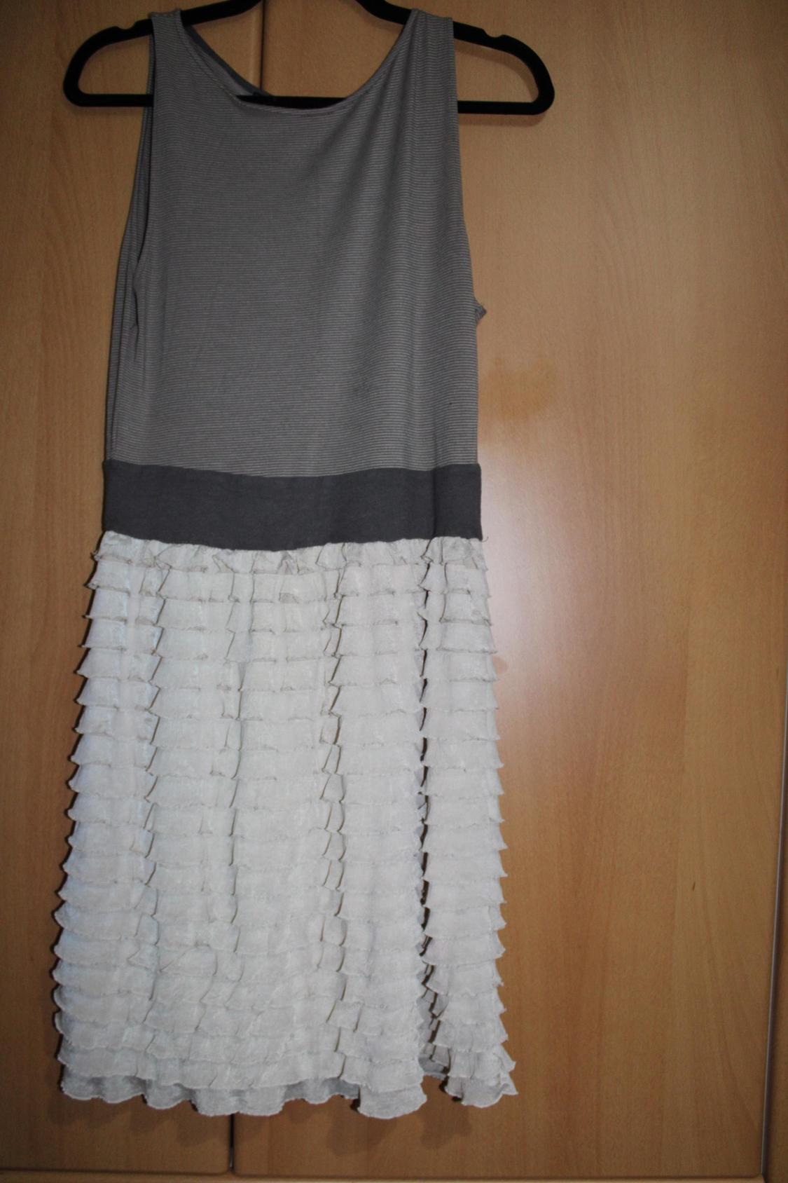 Grey sleeveless dress with a white frill skirt.