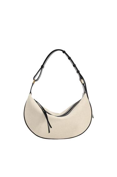 Beige shoulder bag with details and adjustable black strap on a white background. Modern and minimalist design.