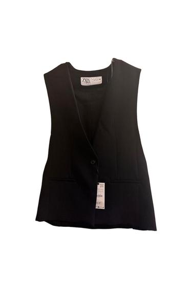 Sleeveless black vest with visible tag, hanging on a white background. Inner tag with "ZARA" text.