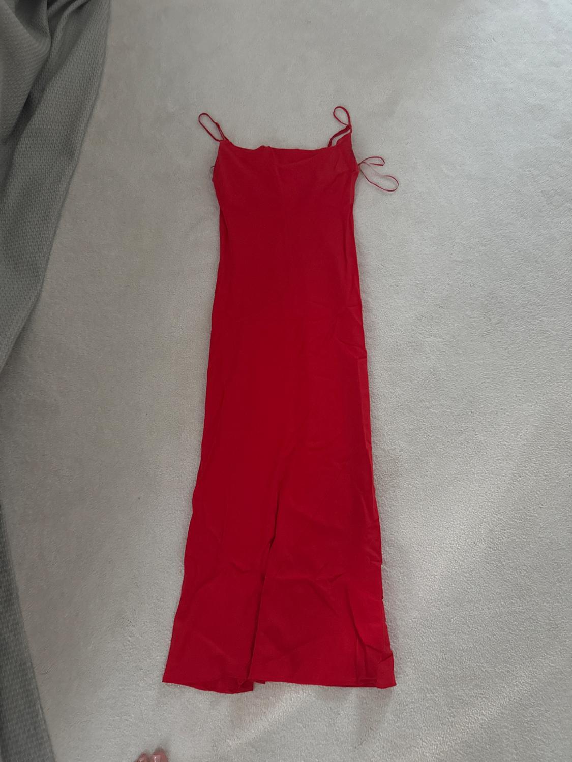 Front view of a long red dress with thin straps.