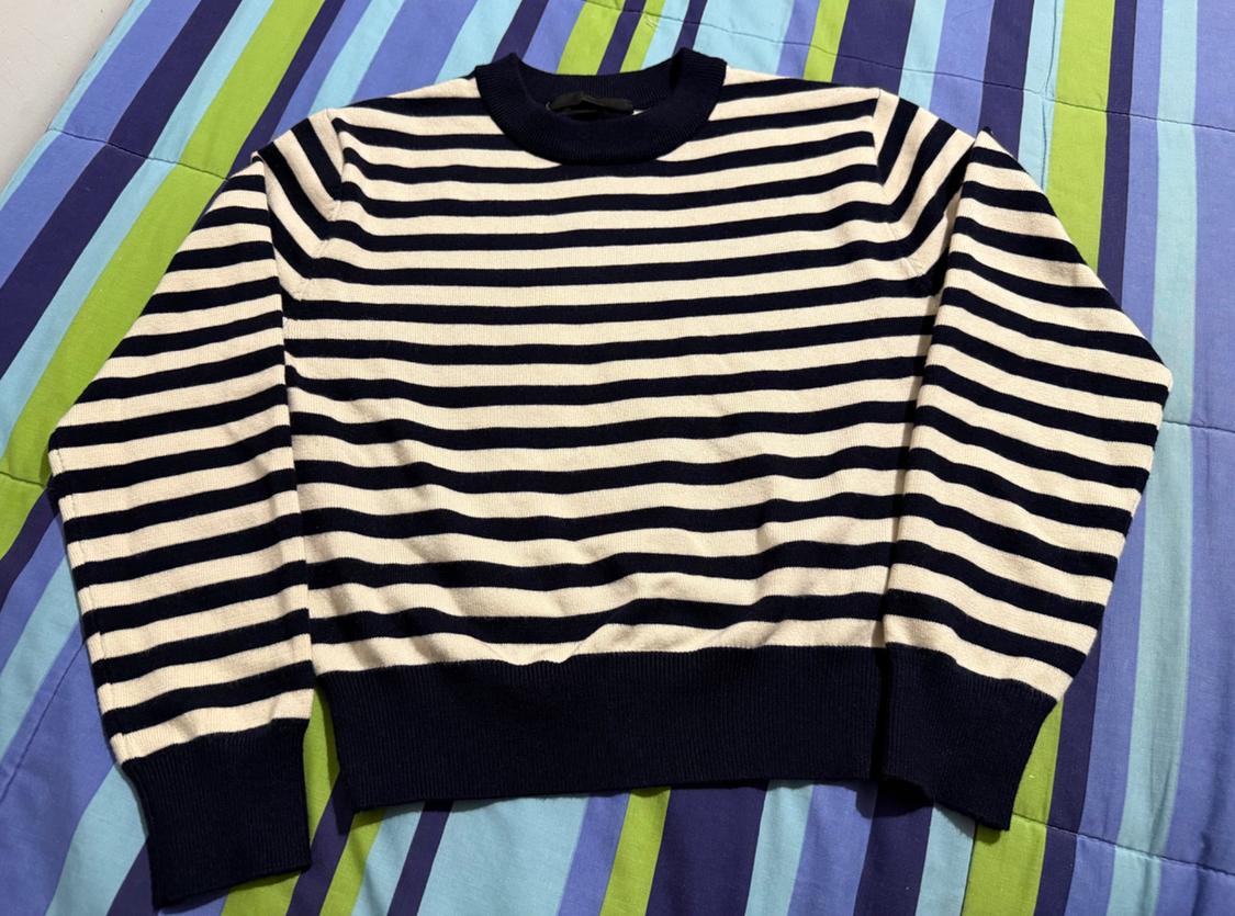 Black and white horizontal striped jumper on a blue and green striped quilt.