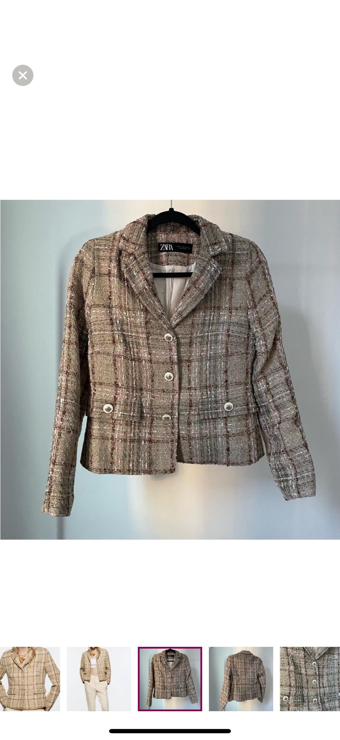 Brown and beige plaid jacket with white buttons, hanging on a black hanger. Label visible on the neck.