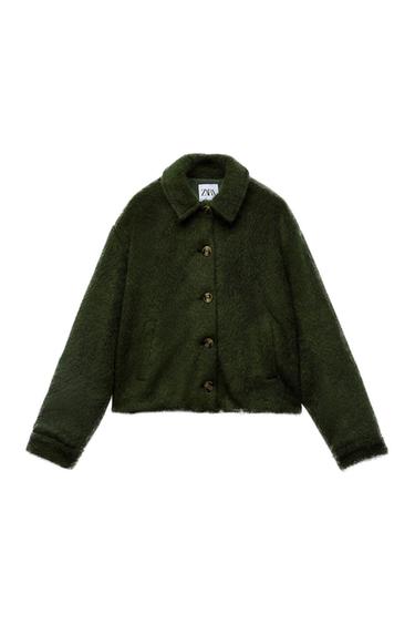 Soft-textured green jacket with front buttons and classic collar. Visible label with the text "ZARA" on the inside of the neck.