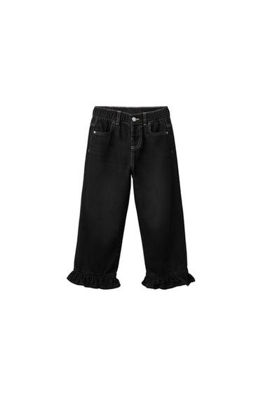 Front view of black baby pants with elastic waistband, front pockets, and ruffles at the bottom.