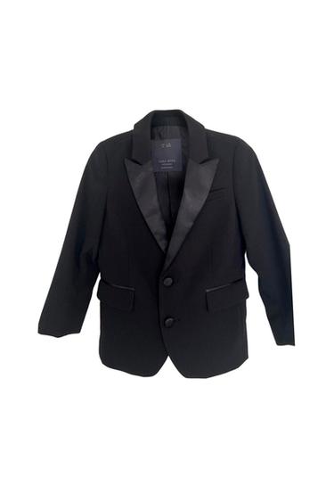 Black jacket with satin lapels, two buttons, and pockets on a white background. Inside tag: ZARA BOYS collection.