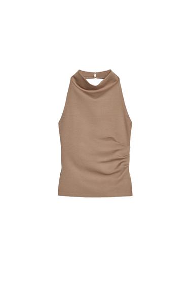 Front view of a sleeveless beige top with a cowl neck.