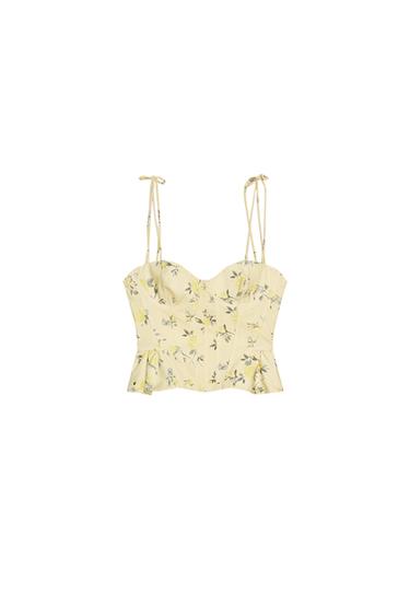 Front view of a yellow top with floral print, sweetheart neckline, adjustable thin straps, and back zip closure.