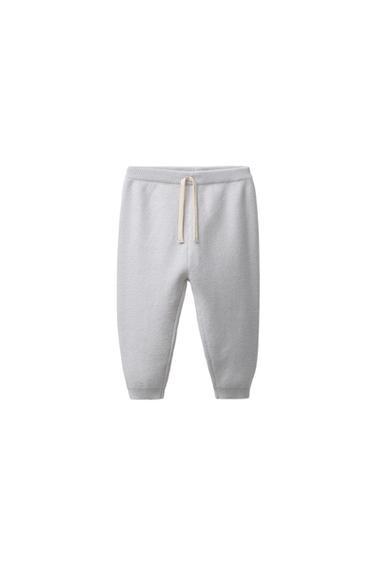 Front view of light gray jogger pants with elastic waistband, front drawstrings, and patch pocket on the back.