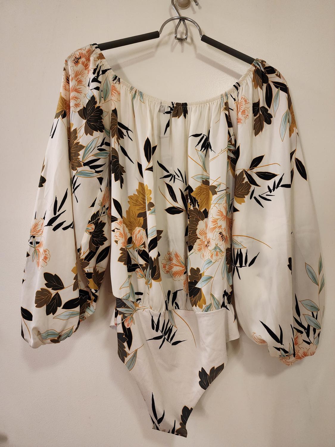 Front view of floral bodysuit with long puffy sleeves and elastic neckline, brown and beige floral print.