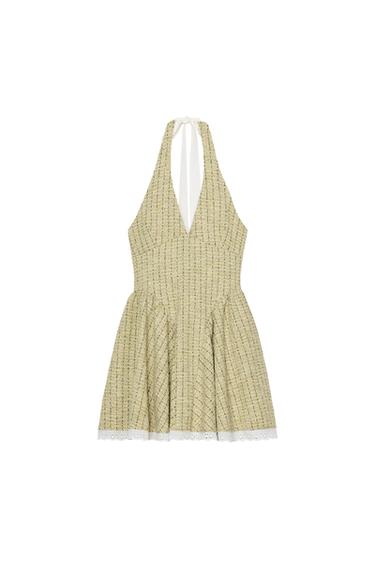 Front view of a short green dress with a halter neck and a flared hem. Tie fastening at the neck.