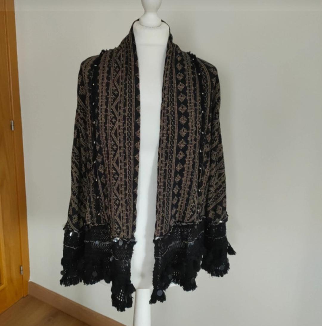 Front view of jacket with black and brown geometric pattern, black lace fringe edges.