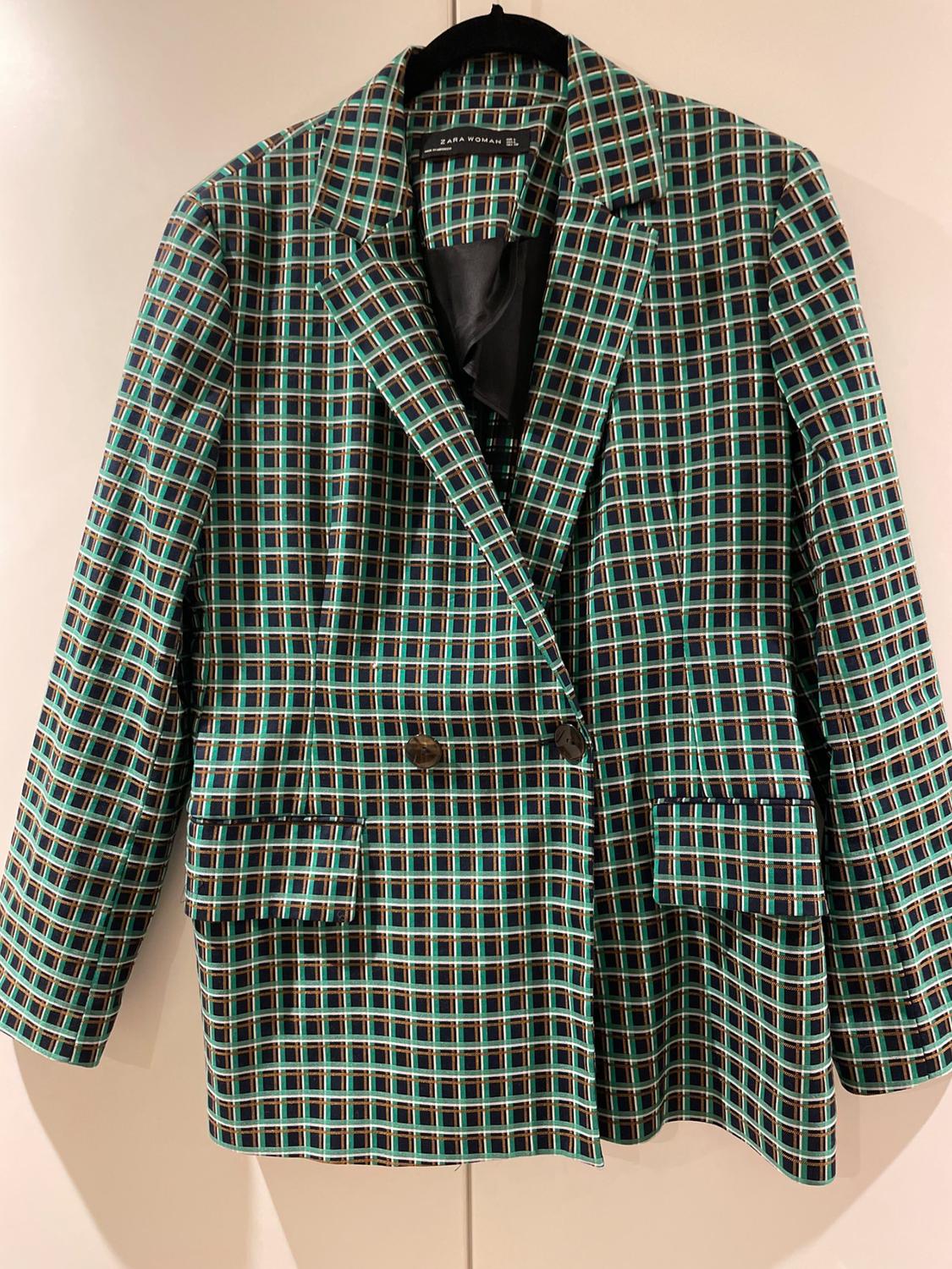 Front view of blazer with green and blue checked pattern, classic lapels and flap pockets.