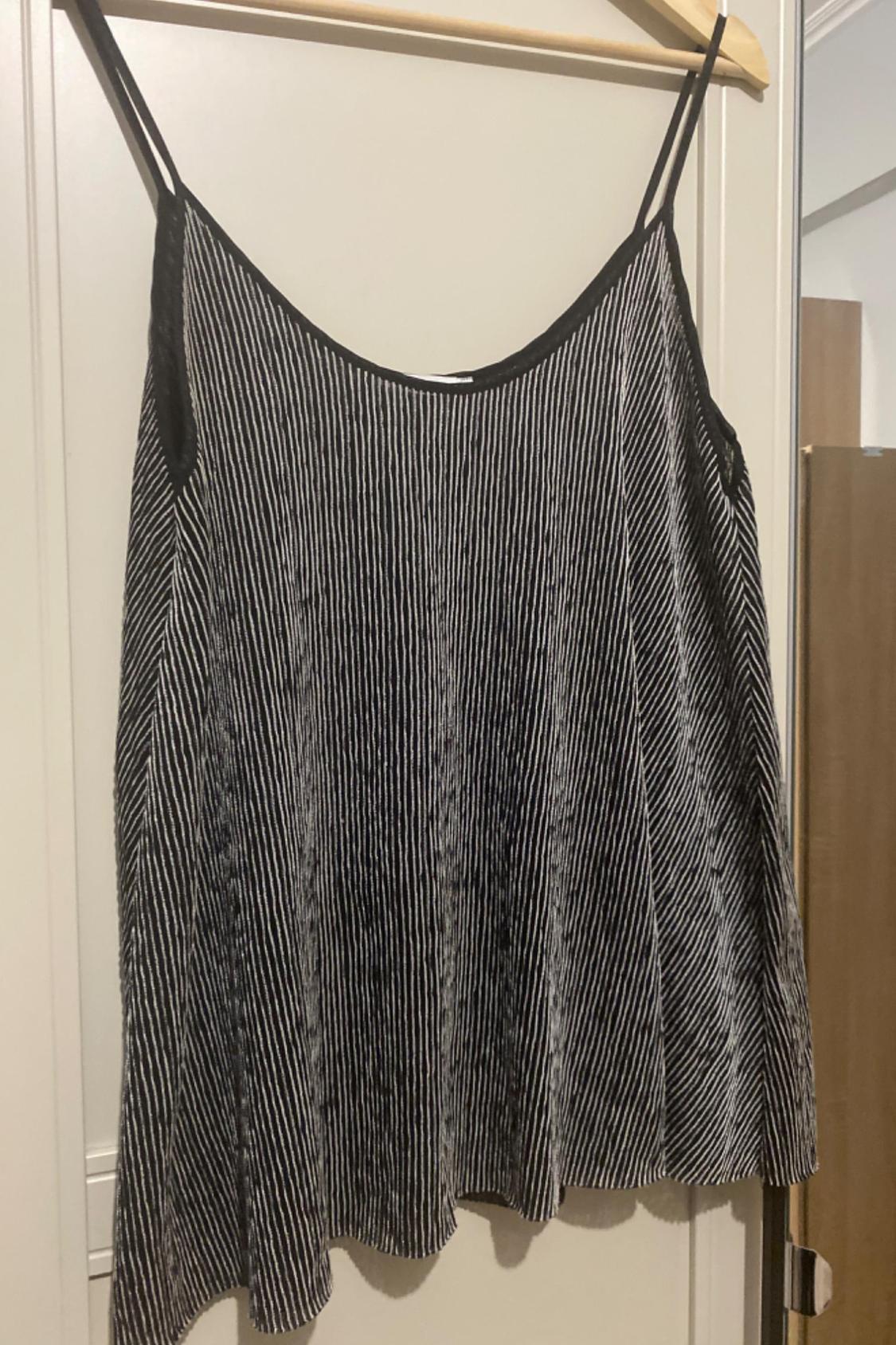 Front view of a black and white vertical striped camisole top.