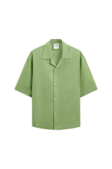Front view of a green plaid shirt with front pockets and a classic collar.