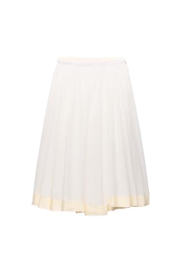 White romantic-style skirt with a flared cut, soft pleats and a cream-toned hem strip, on a white background.