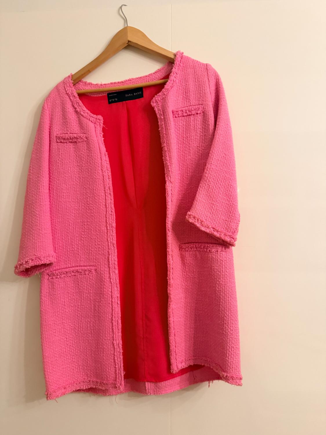 Open textured pink jacket with frayed edges, hanging on a wooden hanger against a white background. Visible label: ZARA BASIC.