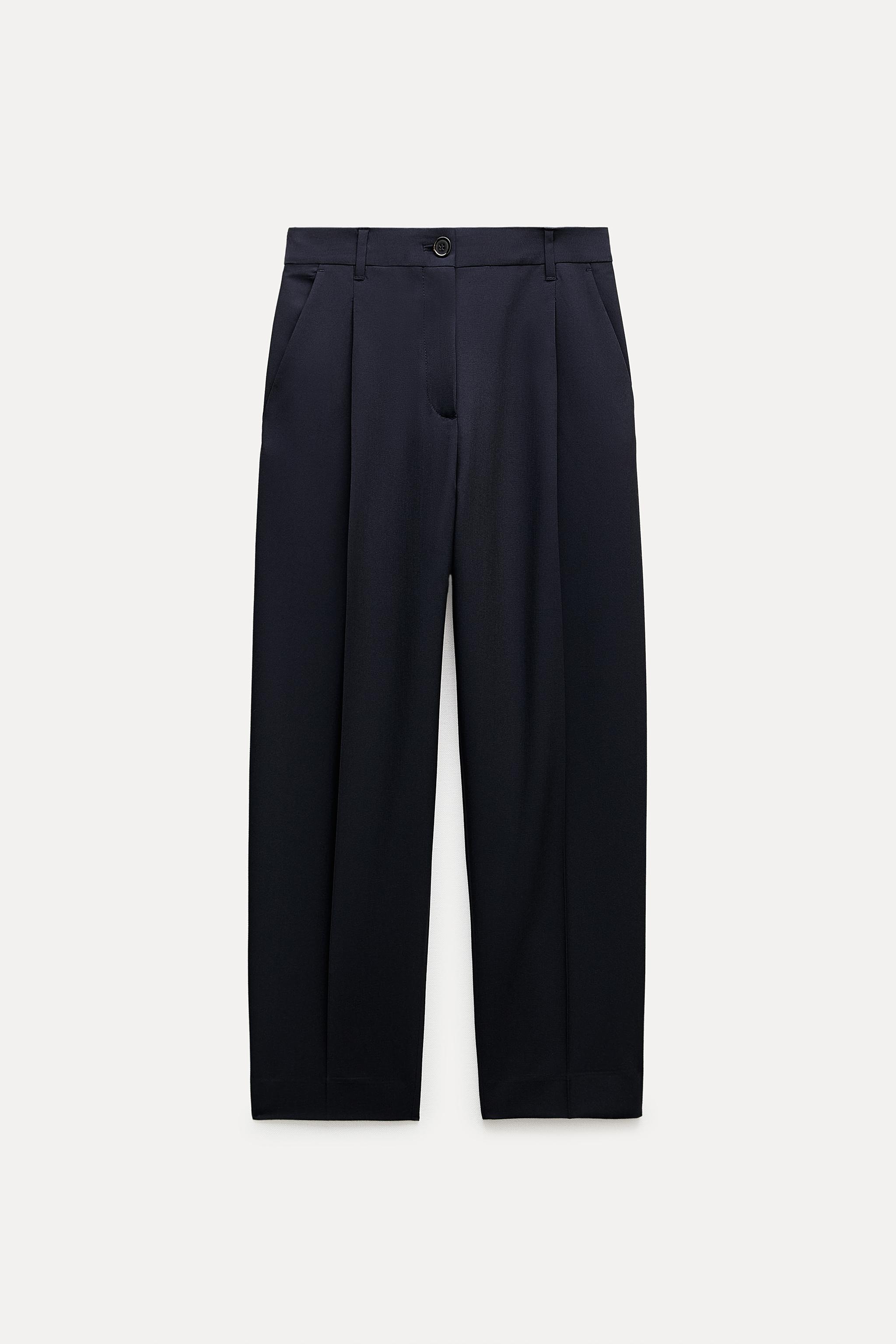 Pants with a high front wrap waist and snap button. Wide leg. Side