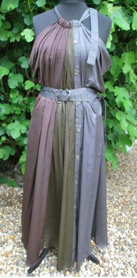 Long dress in shades of brown and grey on a mannequin, with a grey belt and a green leaf background.