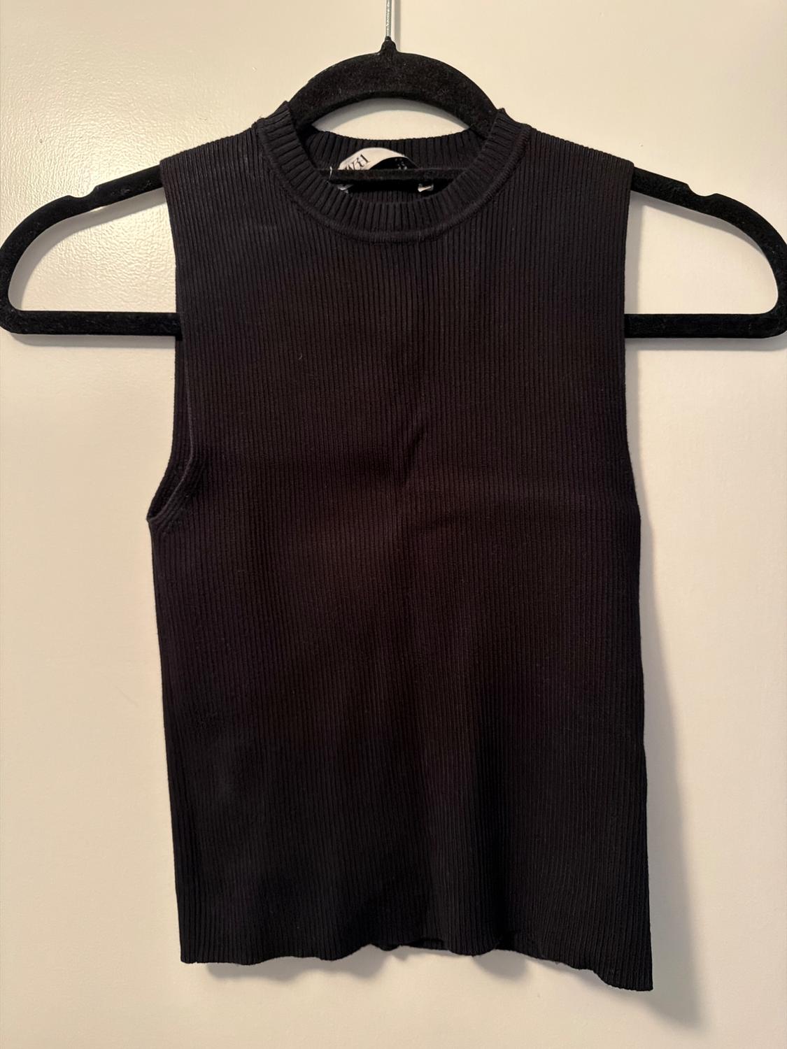Black ribbed sleeveless top hanging on a black hanger against a white background.