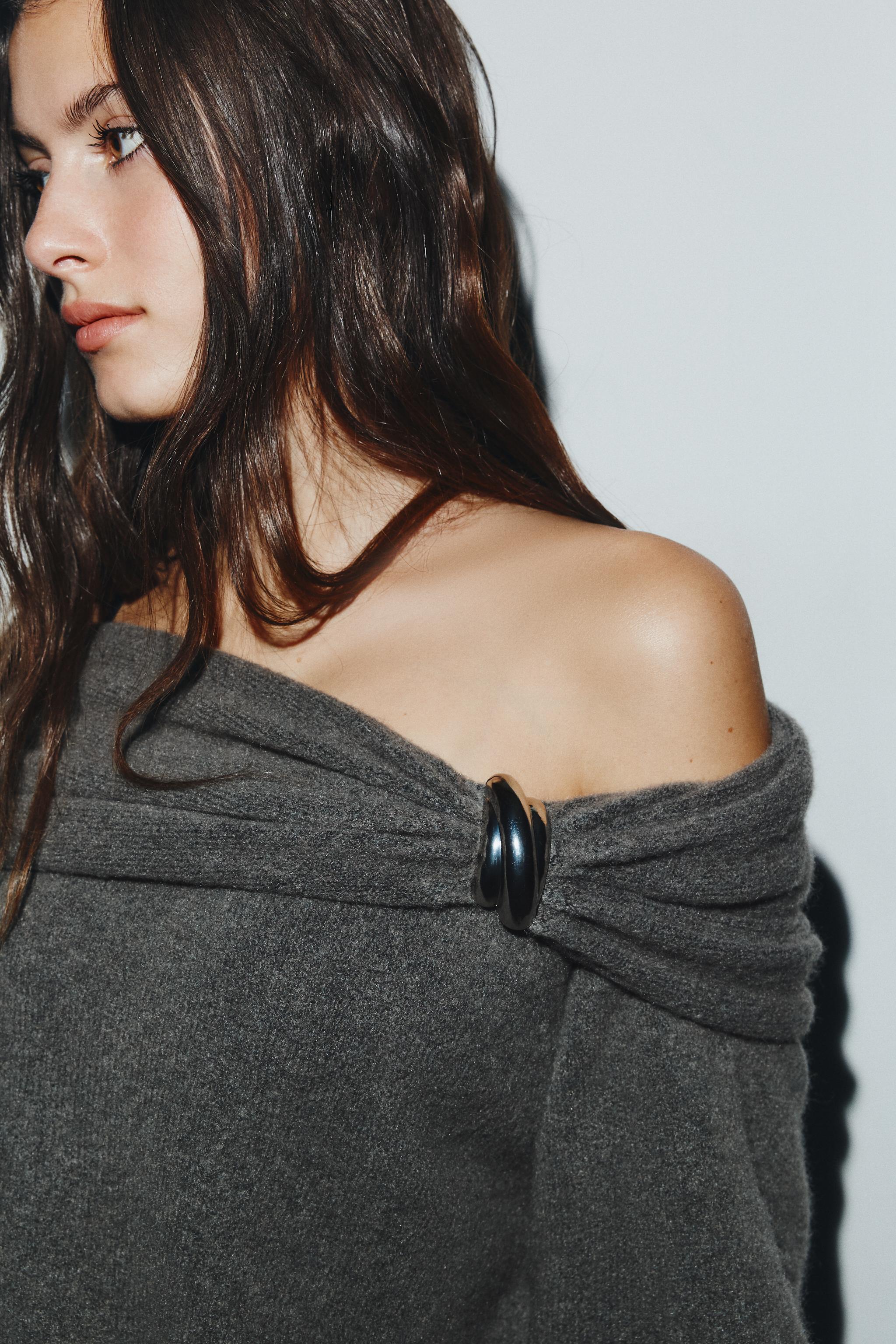 OFF-SHOULDER KNIT SWEATER WITH METALLIC APPLIQUÉ