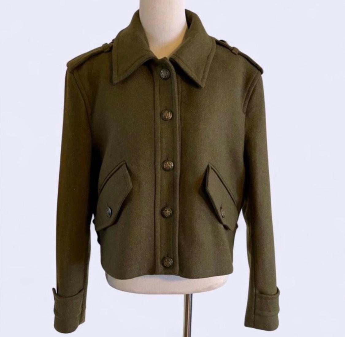 Olive green jacket with front buttons and flap pockets, displayed on a mannequin against a white background.