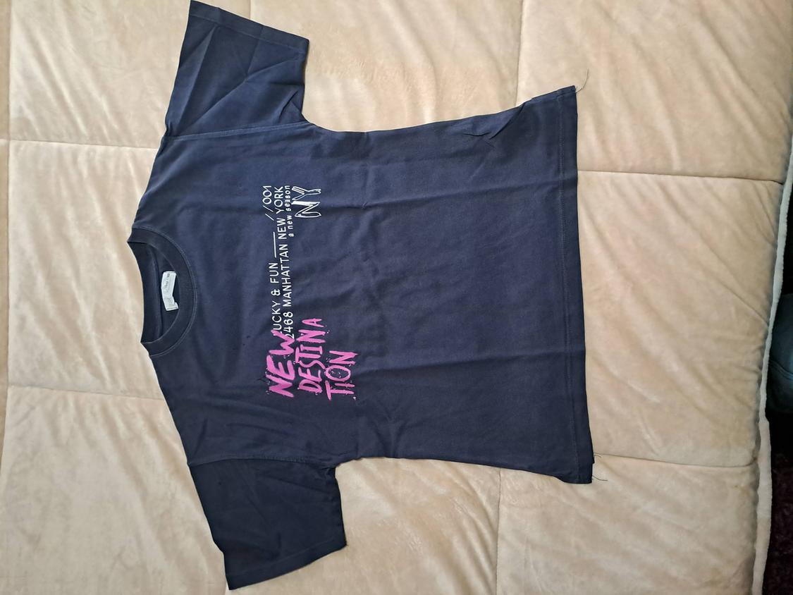 Black T-shirt with text on the front: "NEW DESTINATION" in pink and "LUCKY & FUN 4068 MANHATTAN NEW YORK" in white.