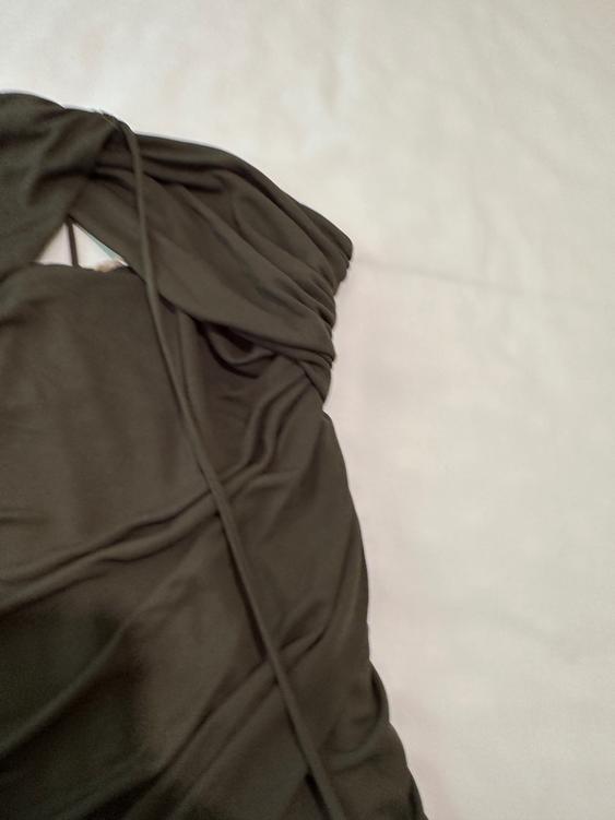 Dark draped fabric on a white background, showing soft texture and elegant folds.