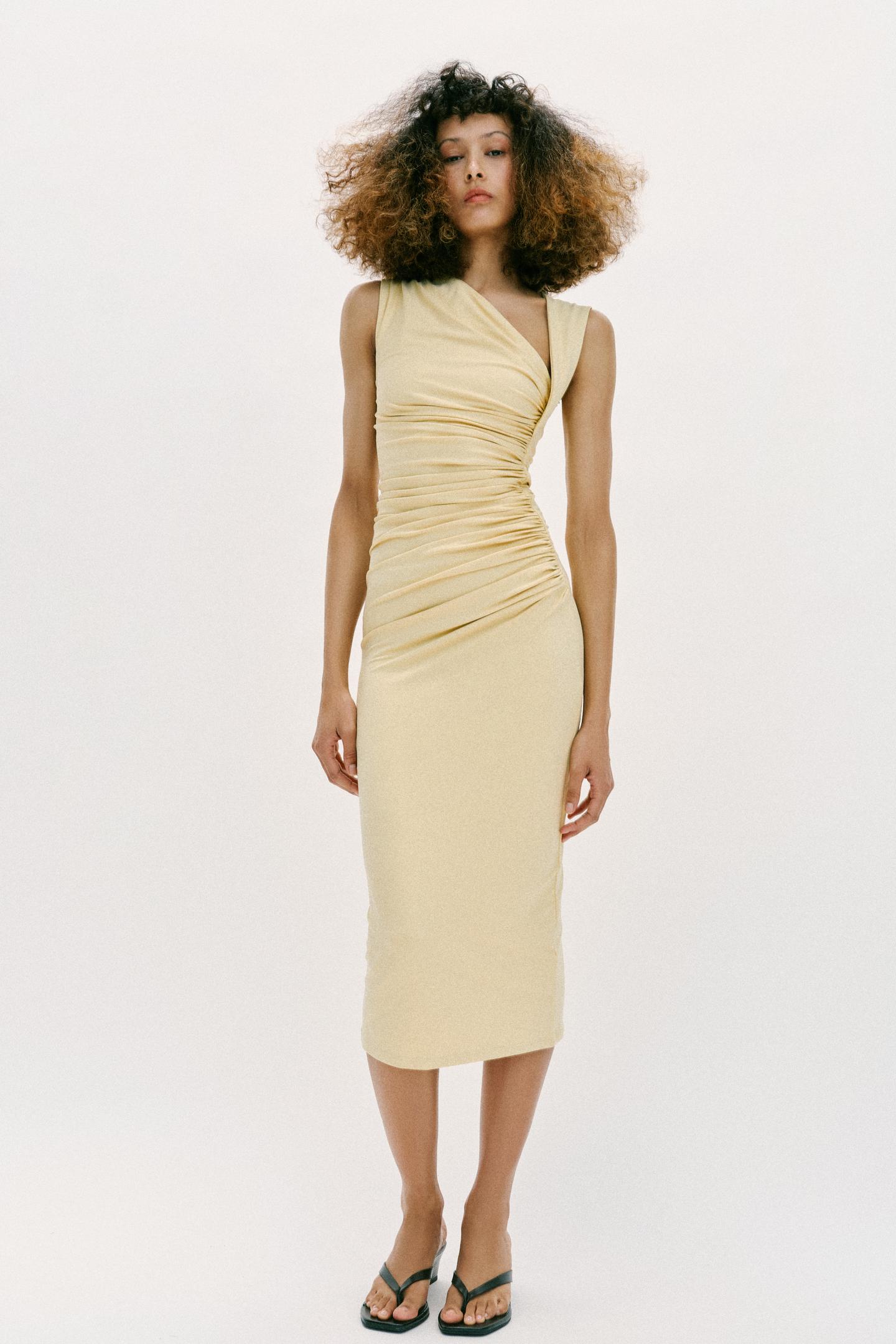 Yellow midi dress set with an asymmetrical neckline, sleeveless design, and front draping. Straight hem.