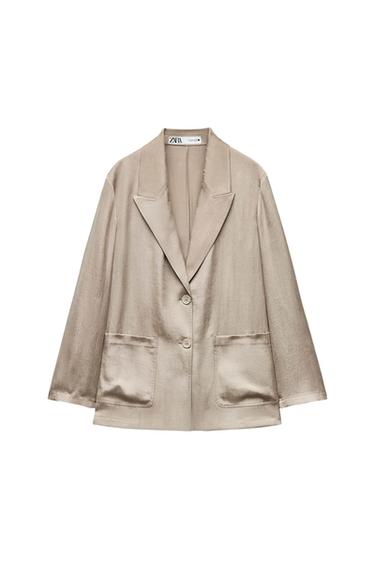 Beige satin jacket with wide lapels, two front buttons, and large pockets. Visible label on the neck.