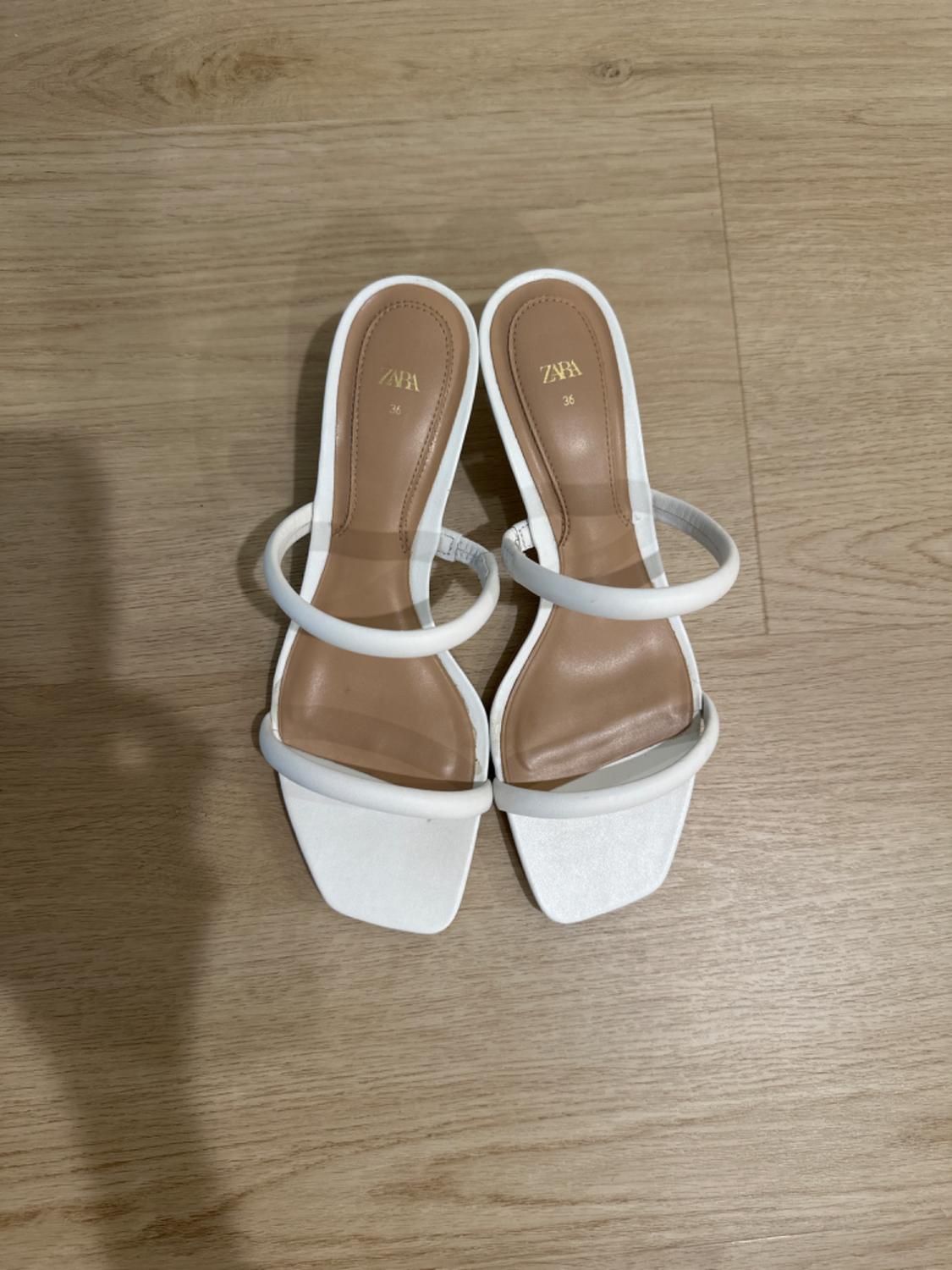 Front view of white square-toe sandals with transparent straps.