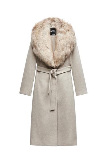 Beige coat with belt and faux fur collar. Visible label with text "ZARA". White background.