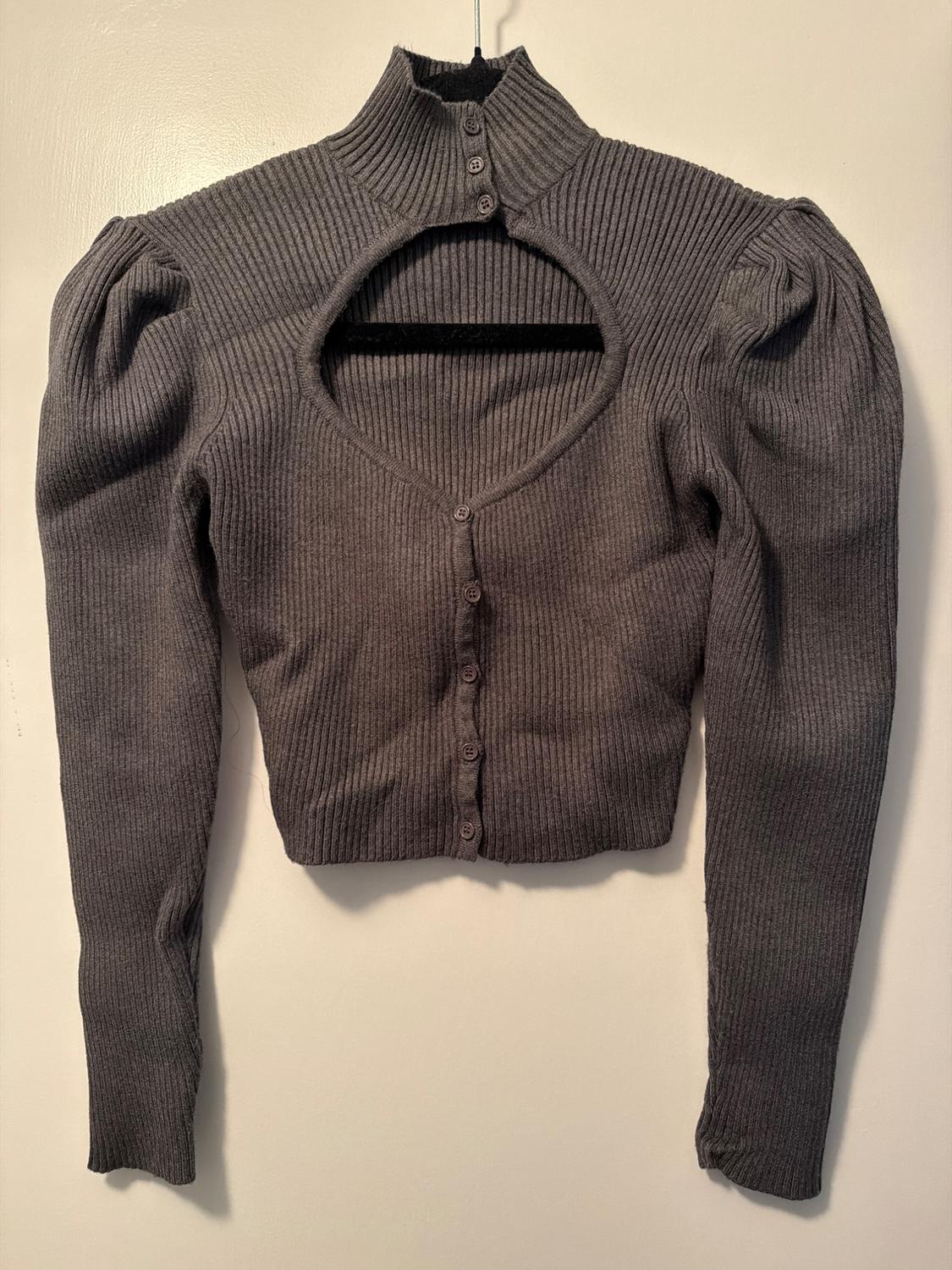Grey ribbed knit cardigan with a high neck, open front, and voluminous long sleeves, hung against a white background.