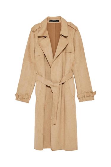 Beige trench coat with a belted waist, lapel collar, and tabs on the shoulders and cuffs. Label with ZARA BASIC text on a white background.