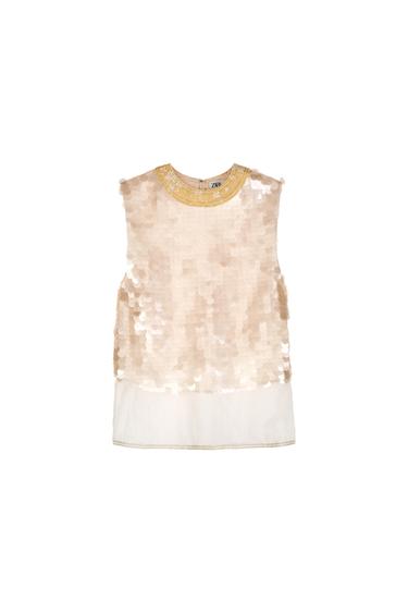 Front view of a beige sequined sleeveless blouse with a decorative yellow collar.
