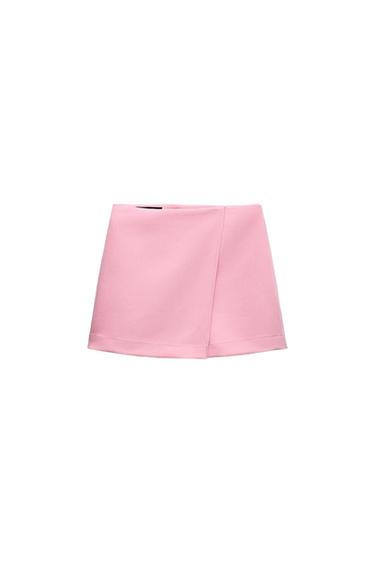 Light pink miniskirt with a wrap-front design on a white background.
