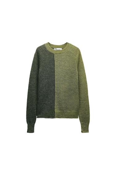 Knitted jumper in two shades of green, dark and light, with a design that is vertically divided. The label is visible on the collar.