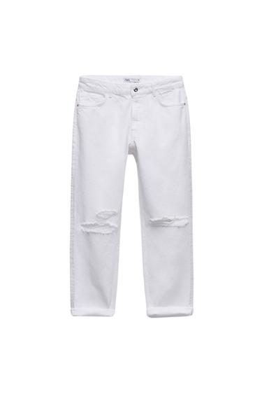 White jeans with rips at the knees and turn-up hems on a white background. Interior label with the text ZARA.