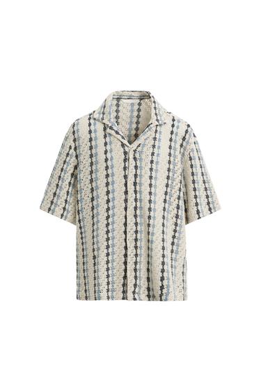 Short-sleeved shirt with a vertical stripe print in shades of blue and black on a white background, with a revere collar.