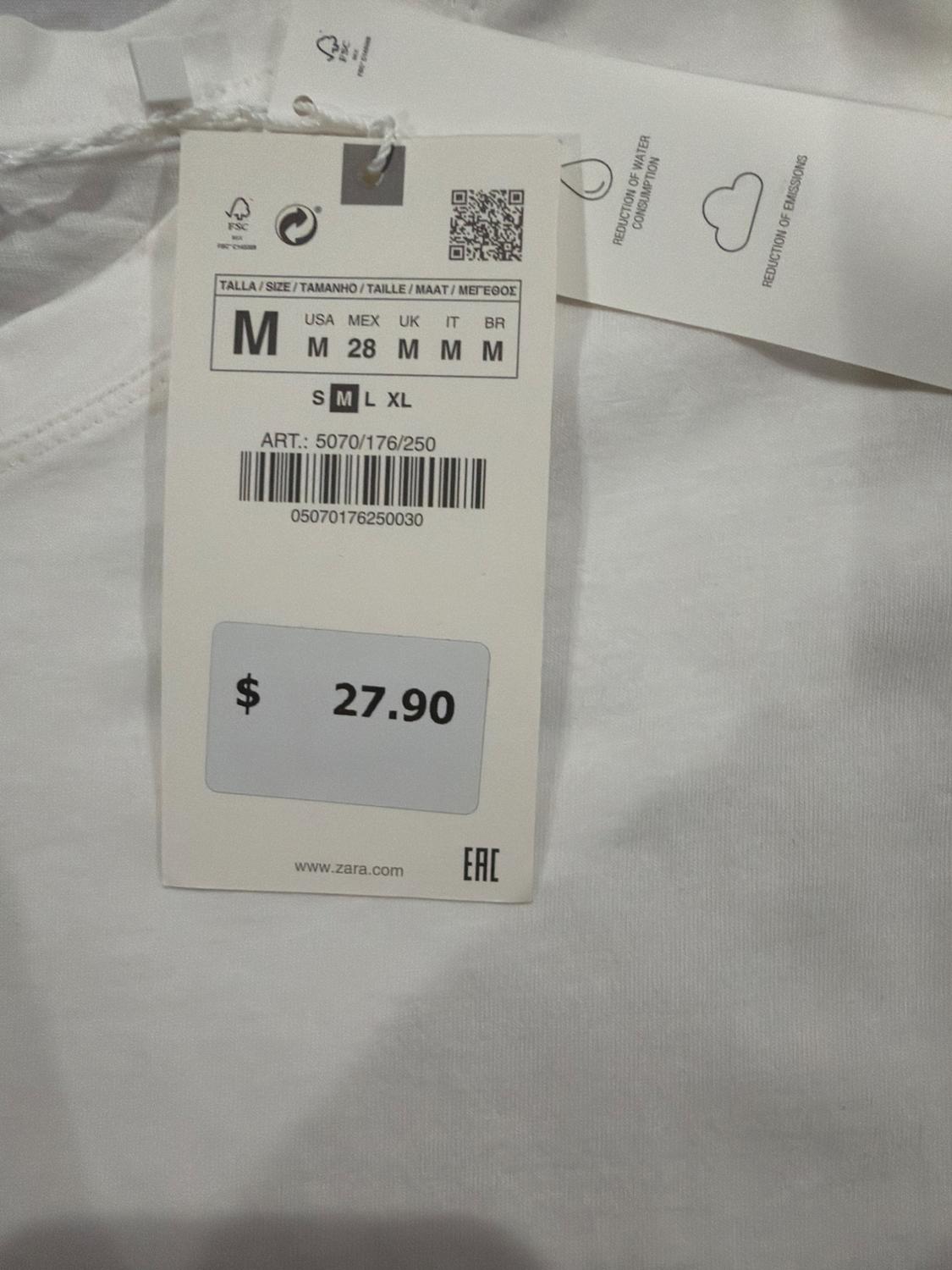 Label on white garment with text: SIZE M, ART.: 5070/176/250, $ 27.90, REDUCTION OF WATER CONSUMPTION.