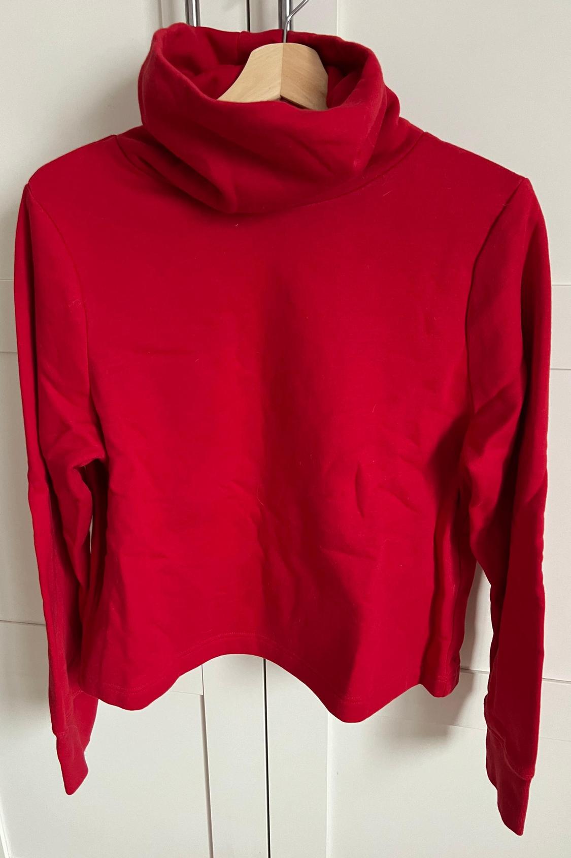 Front view of a red polo neck jumper with long sleeves.