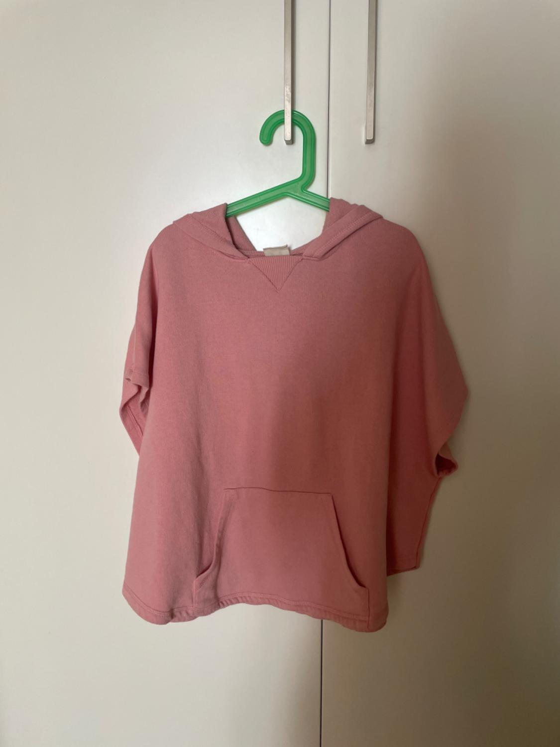 Front view of a pink hooded sweatshirt with a front pocket.