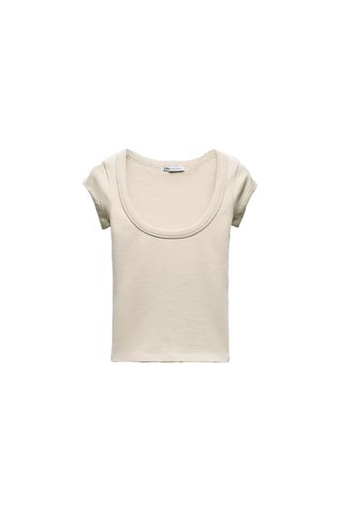 Beige short-sleeved T-shirt with a round neckline on a white background. Visible label on the collar with the text "Zara Collection".